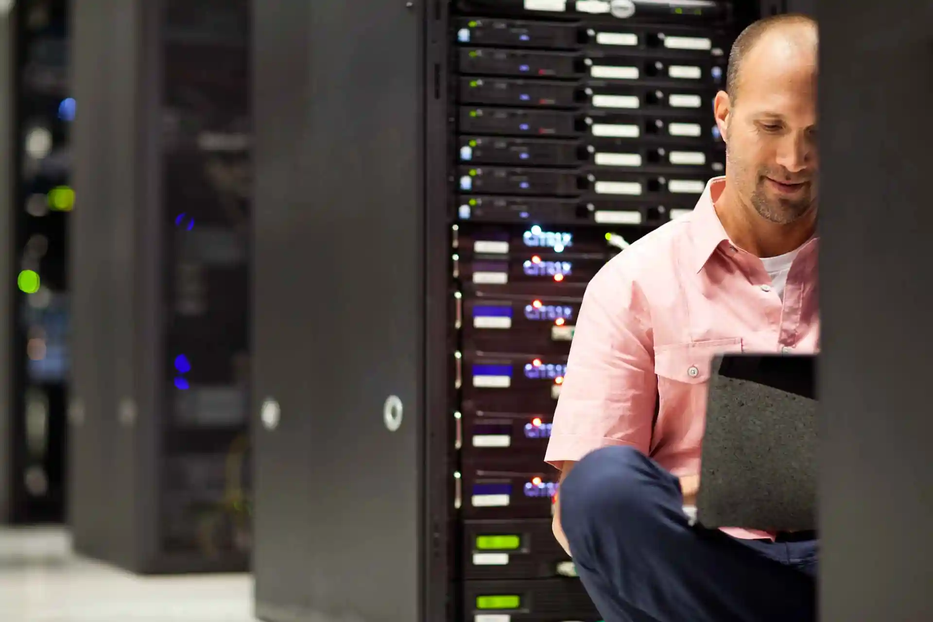 technician working inside data center server rack aisle