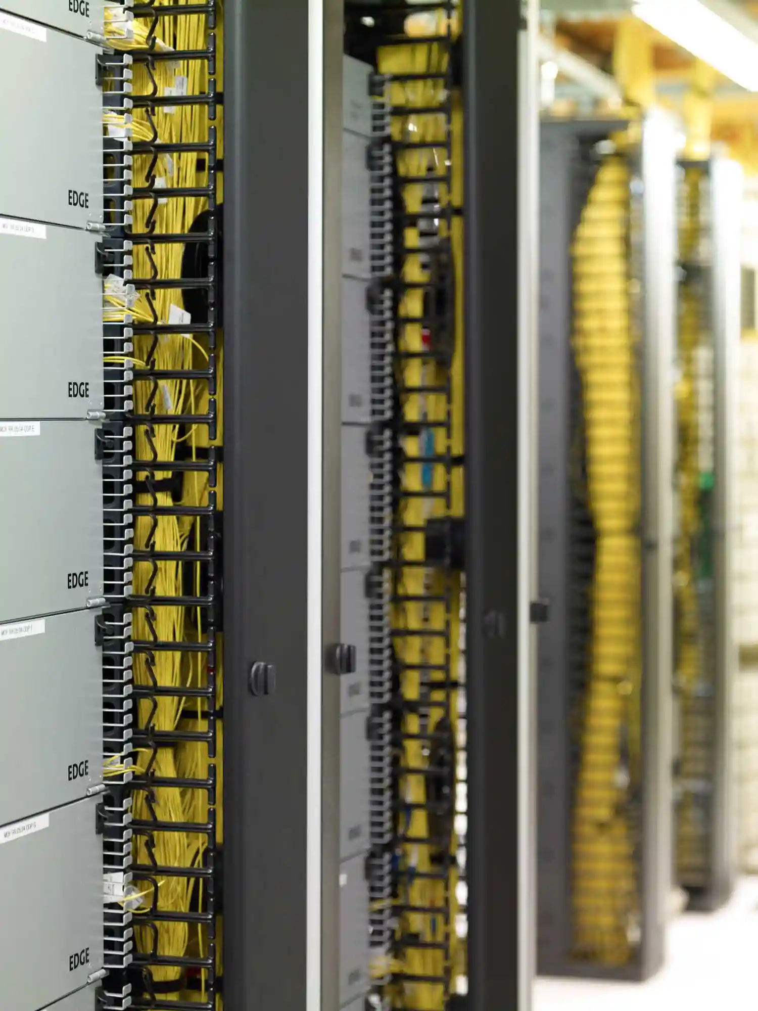 data center network rack with fiber optic patch panels and yellow cables