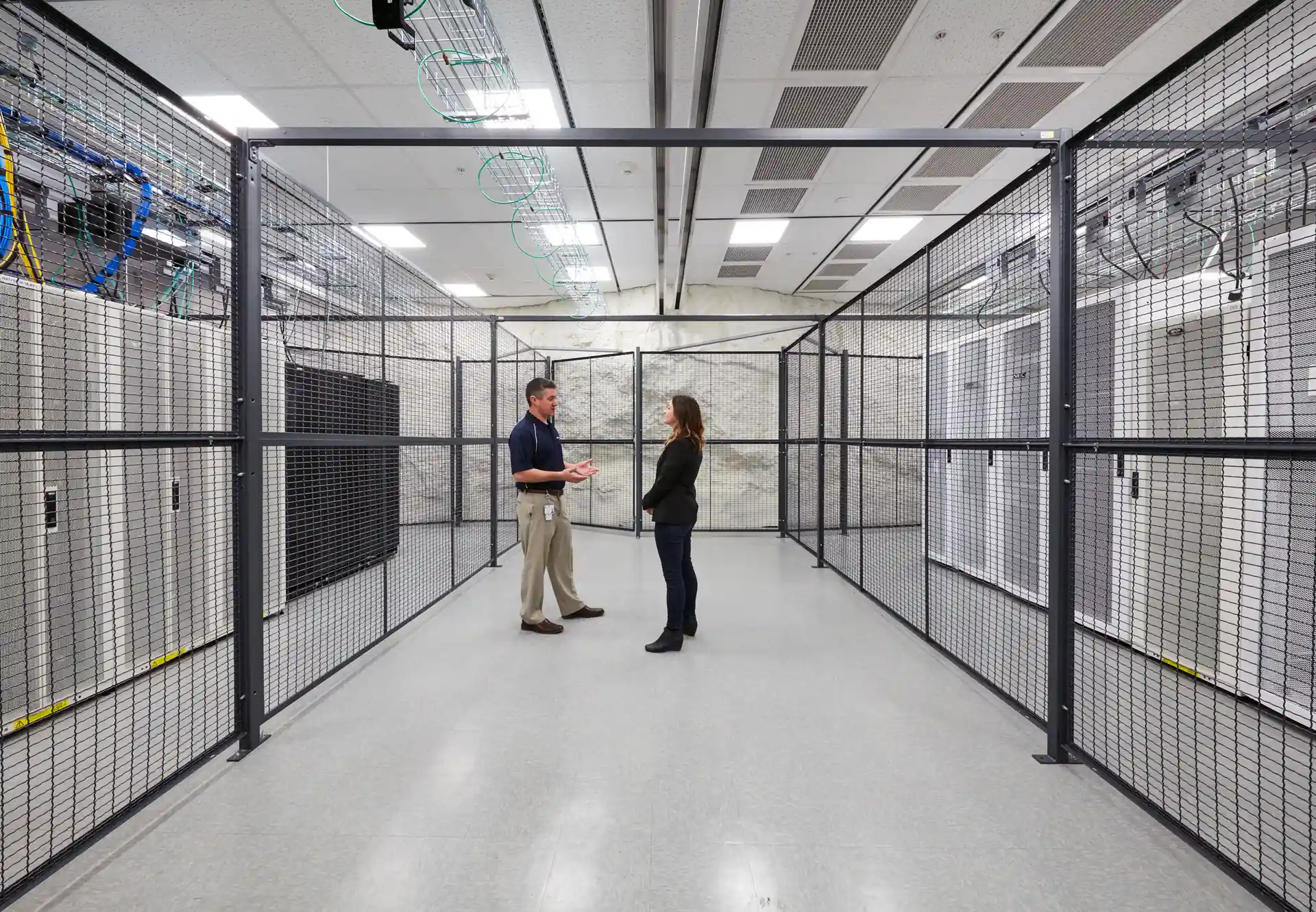 colocation cages inside data center with secure partitioned infrastructure and technicians