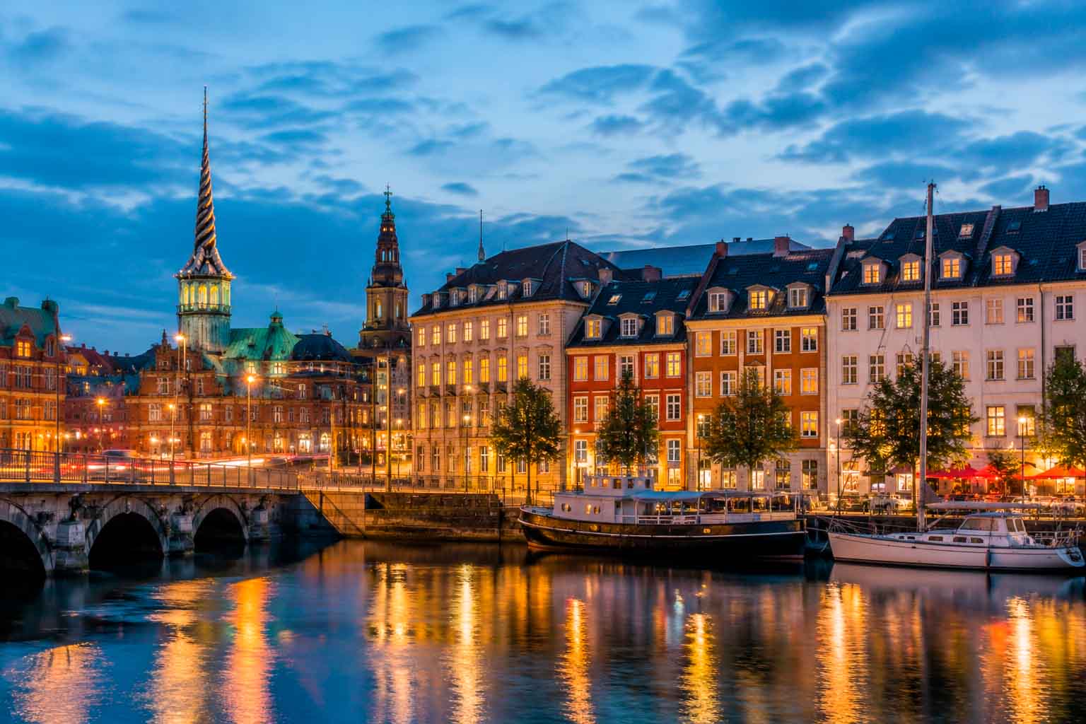 Copenhagen waterfront at dusk with illuminated buildings and harbor reflections, used as a regional context image for data center photographer services.