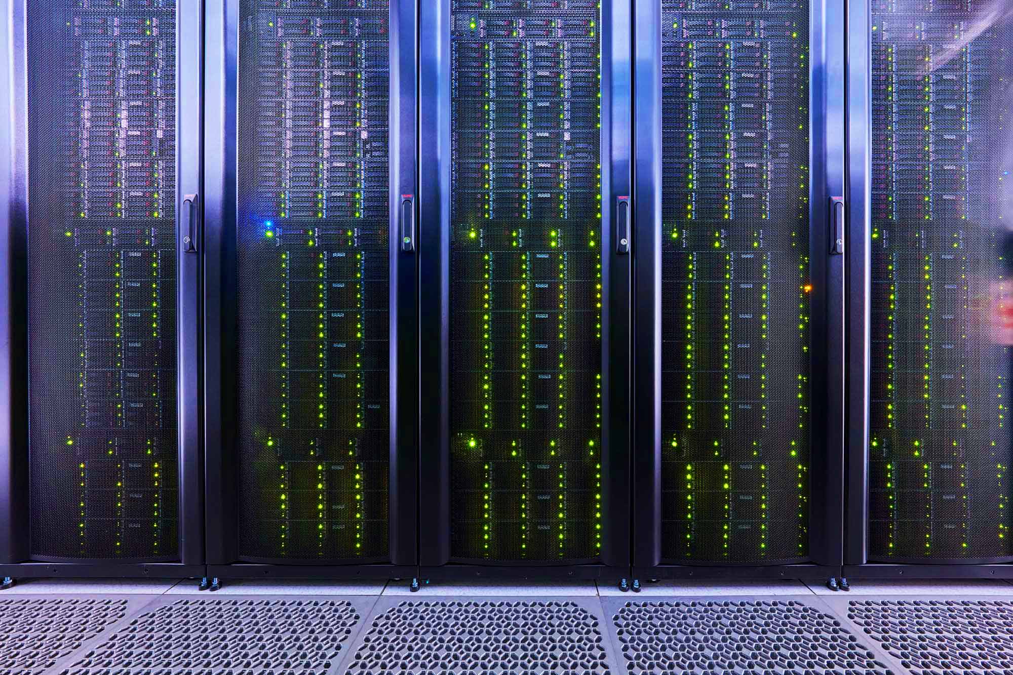 Rows of server racks with glowing indicator lights inside a data center, used as the hero image for professional data center photographer services.