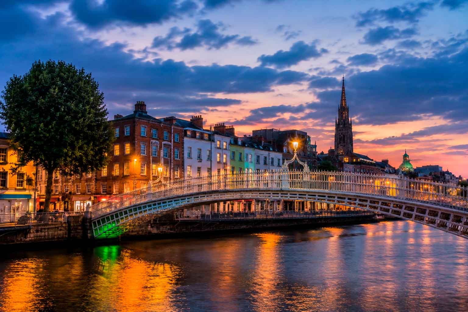 Dublin riverfront at dusk with illuminated buildings, bridge lights, and evening sky, used as a regional context image for data center photographer services.