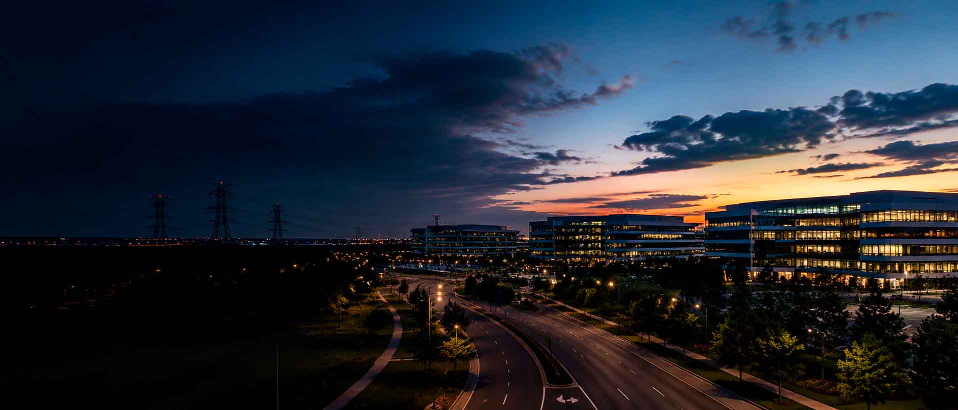 Northern Virginia business corridor at dusk with office buildings, roadways, and infrastructure lighting, used as a regional context image for data center photographer services.