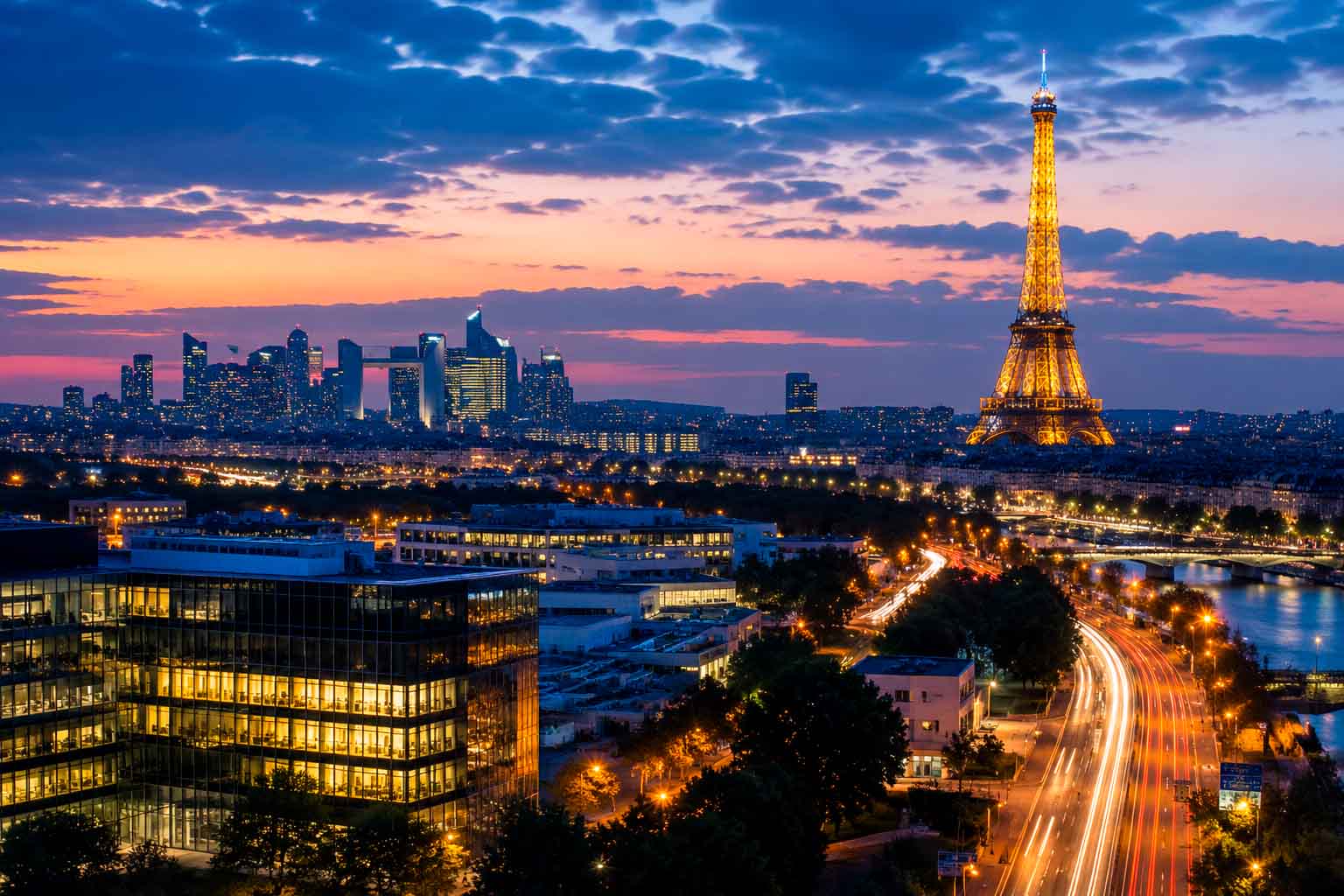 Paris skyline at dusk with illuminated buildings and La Défense in the distance, used as a regional context image for data center photographer services.