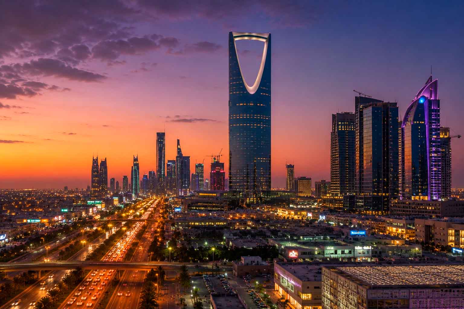 Riyadh skyline at dusk with illuminated towers, highways, and evening traffic, used as a regional context image for data center photographer services.
